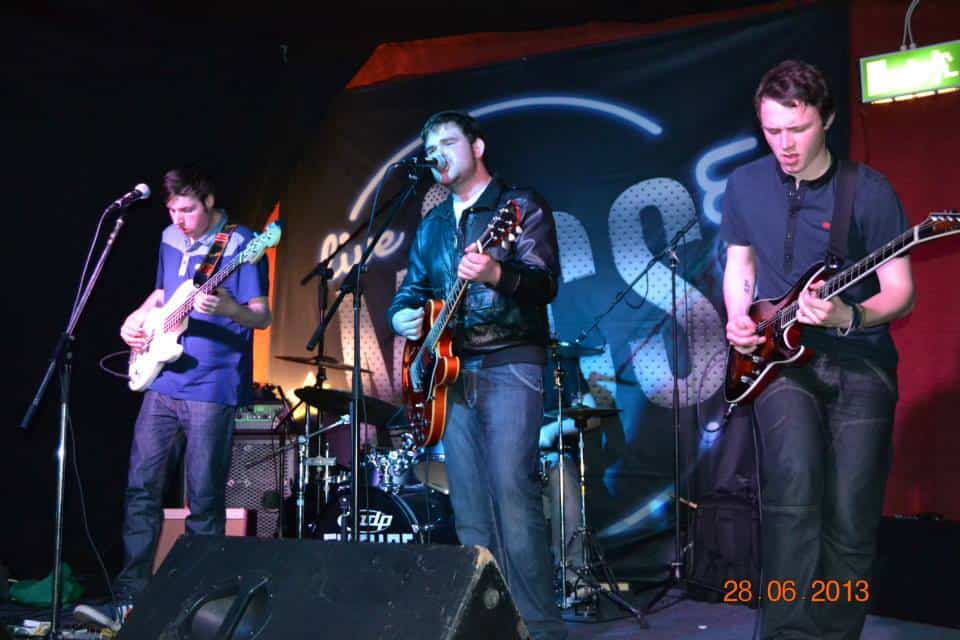 Young musicians performing live on stage at a music event.