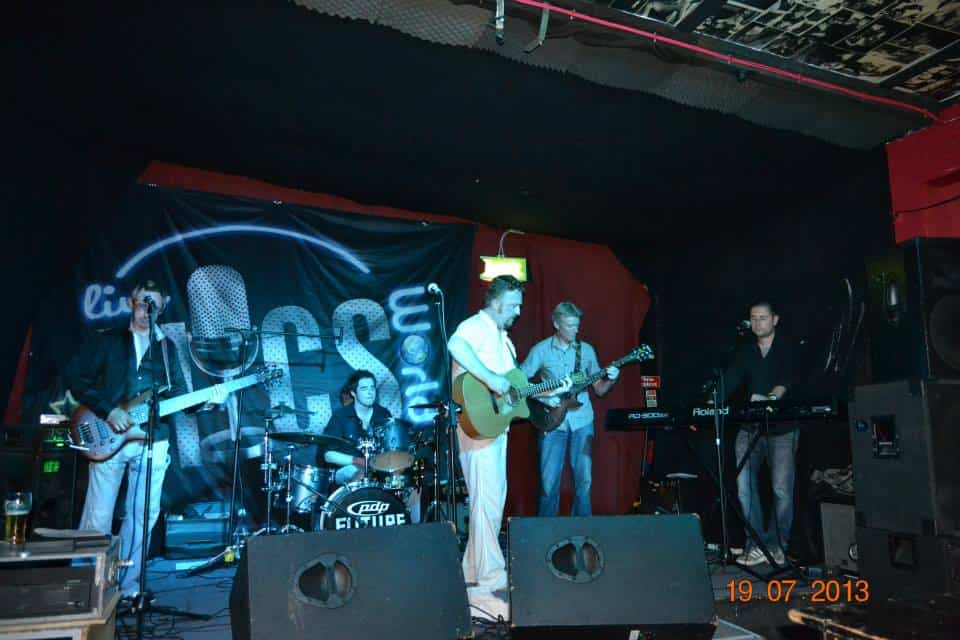 Live band performing at an independent music event in a club setting.