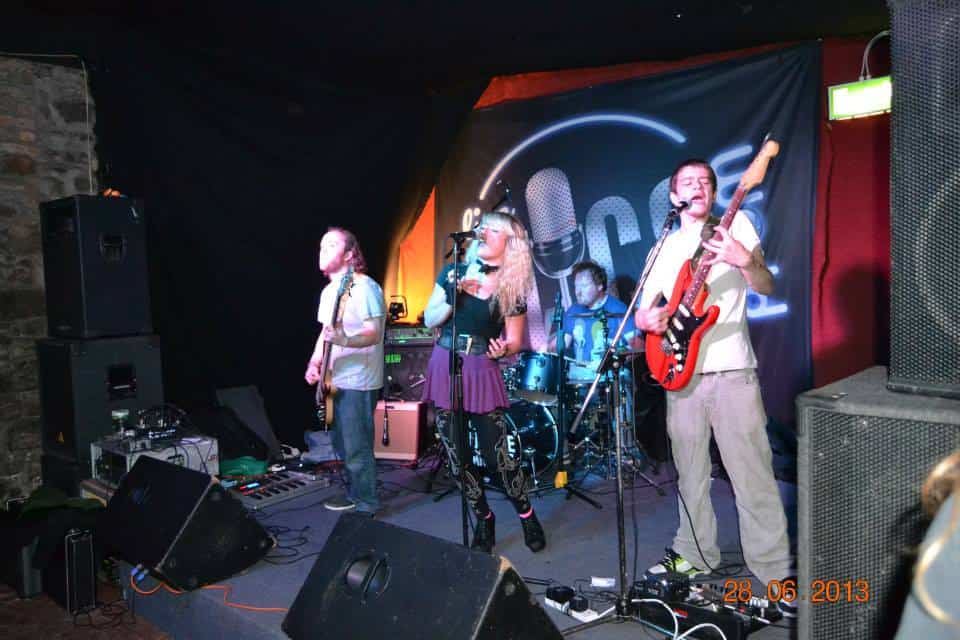 Diverse musicians performing live on stage at a music event.