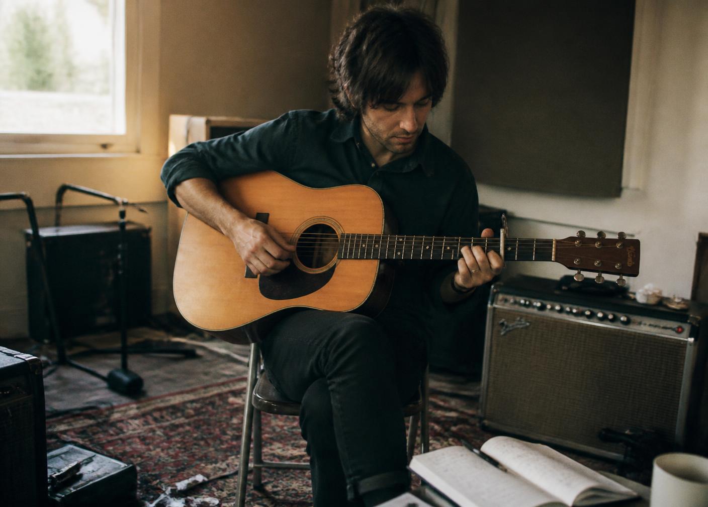 Independent musician playing acoustic guitar in a rehearsal room